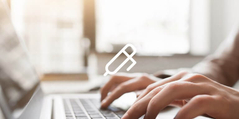 An image showing a laptop screen and a pair of hands writing on a keyboard.