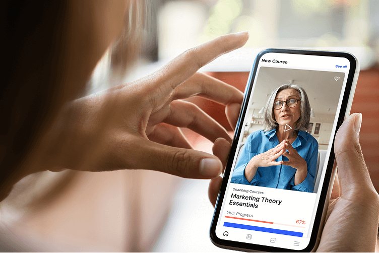 A close-up of a person holding a smartphone that displays a video lesson of a healthcare instructor.