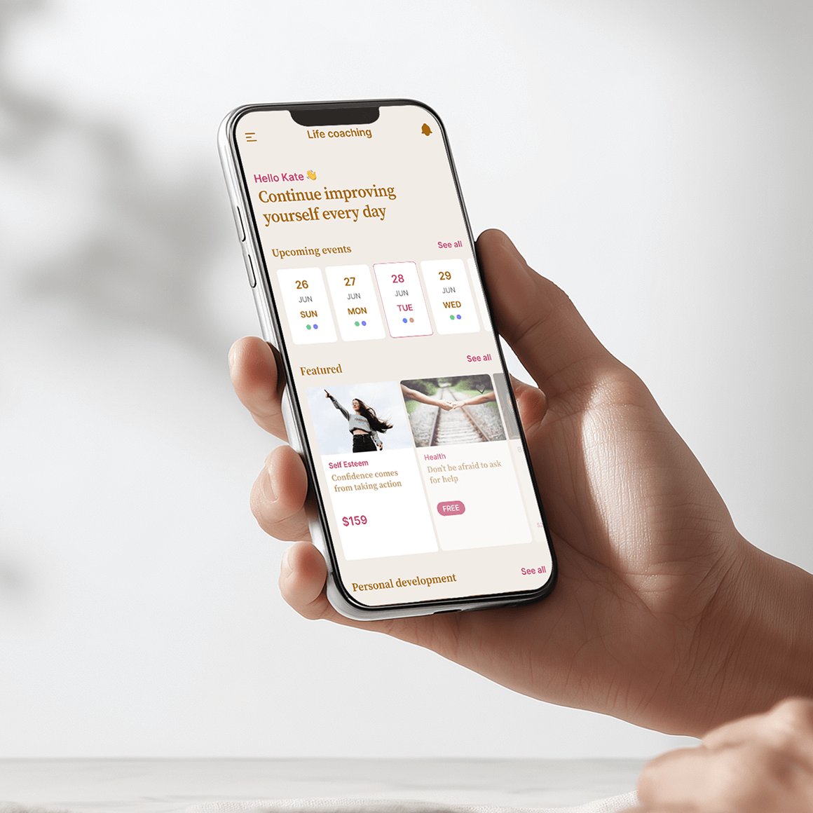 An image of a hand holding a mobile   showing a course page on screen.