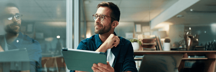 Business professional using a laptop in an office environment.