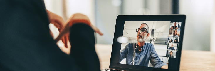 Person using a laptop with a video call on screen.