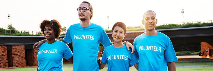 Group of children/teens outdoors in matching shirts, smiling.