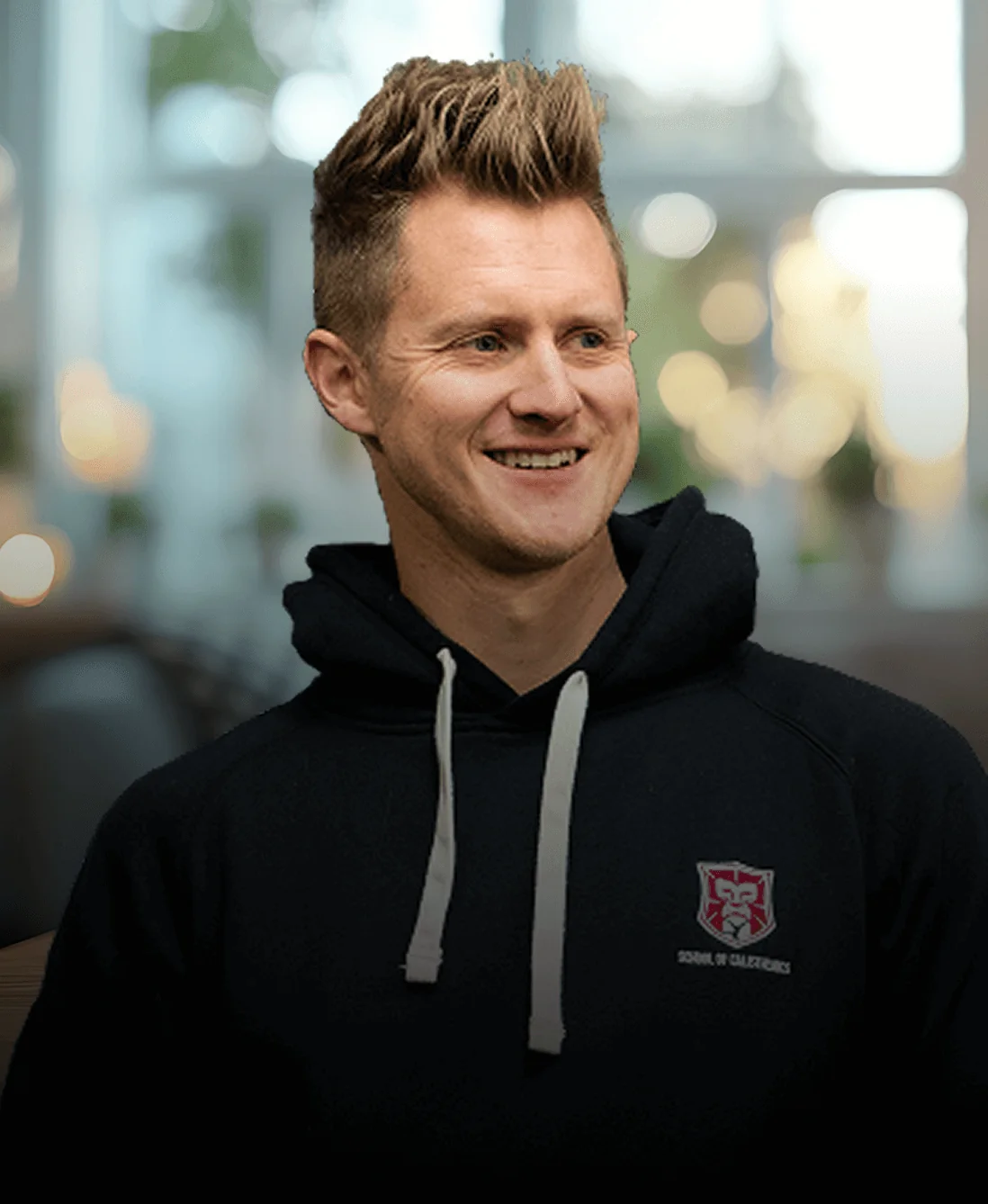 Man in a tan coat smiling and talking on a phone while holding coffee; standing by a modern office façade; left-side hero text and buttons promote a...
